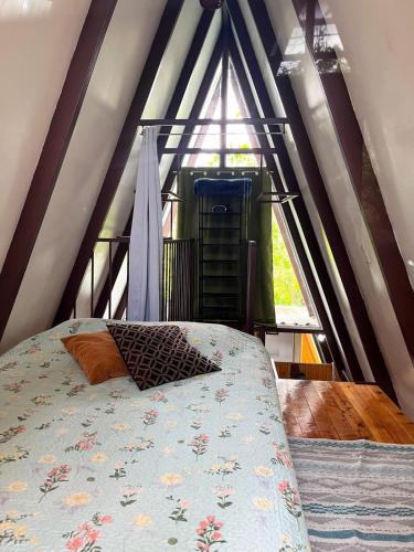 a bedroom with a bed in front of a window at Cabaña Azalea en Santa María de Dota in Santa María