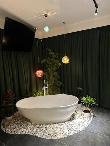 a large white bath tub in a room with plants at Balandda Chimgan in Chimgan