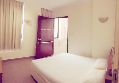 a bedroom with a bed and a door to a window at Golden Star Hotel in Singapore