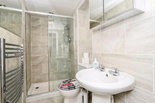 a bathroom with a sink and a toilet and a shower at Gorgeous First Floor apartment near Station in London
