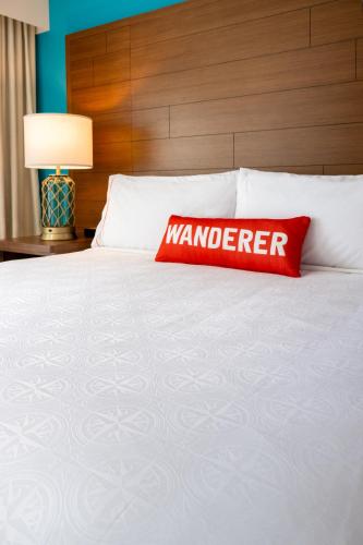 a red pillow sitting on top of a bed at Compass by Margaritaville Hotel Pigeon Forge in Pigeon Forge