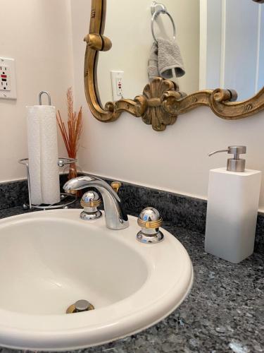 a bathroom sink with a mirror and a candle at Cozy Guest Rooms Near UBC, Downtown and Beaches in Vancouver