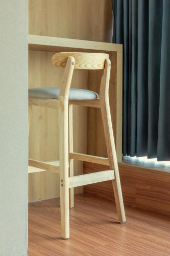 a wooden stool sitting in front of a window at E Lim Hotel in Zhongli