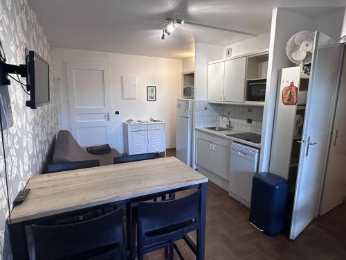 une petite cuisine avec une table et un réfrigérateur dans l'établissement Confortable T2 Bis aux Issambres avec terrasse et accès piscine et tennis - FR-1-768-109, à Roquebrune-sur Argens