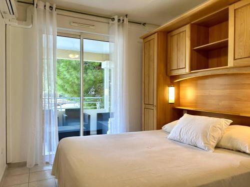 une chambre avec un lit et une grande fenêtre dans l'établissement Appartement climatisé 2 pièces avec terrasse et parking au Lavandou - FR-1-251-854, au Lavandou