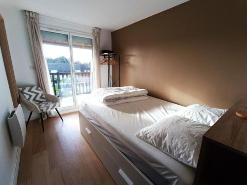 une chambre avec un grand lit et une fenêtre dans l'établissement Appartement en bord de mer, 4 pers, Bernières-sur-Mer - FR-1-746-26, à Bernières-sur-Mer