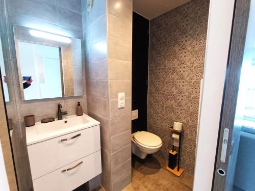 une salle de bain avec toilettes, lavabo et miroir dans l'établissement Appartement en bord de mer, 4 pers, Bernières-sur-Mer - FR-1-746-26, à Bernières-sur-Mer