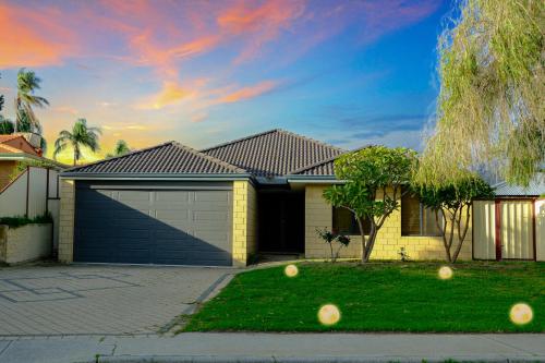 a house with a garage and two balls in the yard at Airport 5BR Haven - Full Kitchen & Tranquil in Perth