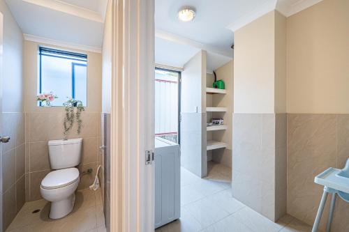 une salle de bain avec toilettes et fenêtre dans l'établissement Airport 5BR Haven - Full Kitchen & Tranquil, à Perth
