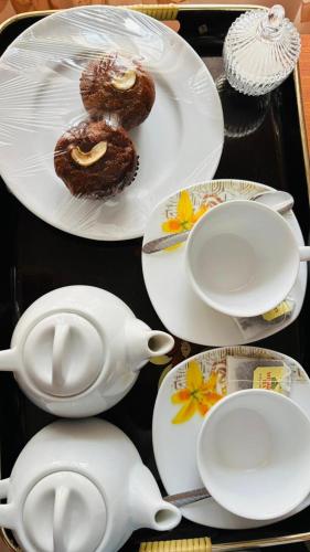 a table topped with white plates and cups and donuts at Mount Side Hiriketiya in Hiriketiya