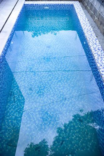 a swimming pool with a reflection in the water at Mahogany Garden Villa Jogja in Ngingas