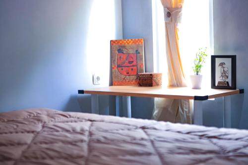 a shelf with a picture and a painting on a bed at Mahogany Garden Villa Jogja in Ngingas