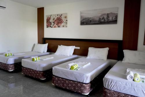 three beds are lined up in a room at El Pergentina Holiday Beach Resort in Siquijor