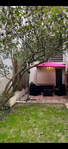 une terrasse avec une couverture rose sur une maison dans l'établissement Paris Orly Aéroport suite, à Athis-Mons