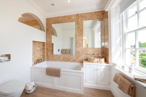 a bathroom with a tub and a sink and a mirror at Prince Hill House in Devizes