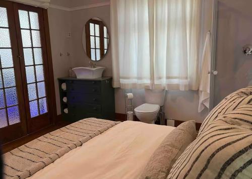 una camera da letto con un letto, un lavandino e uno specchio di Casa Sí Apartment a Gqeberha