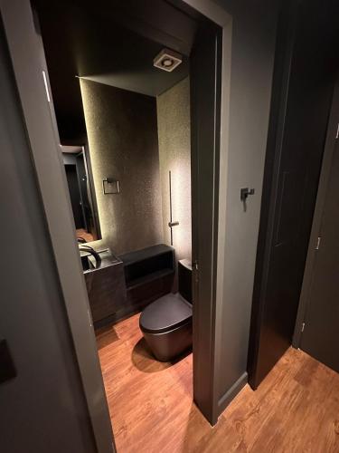 a bathroom with a toilet and a mirror at Loft Duplex com Hidromassagem in Florianópolis