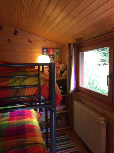 une chambre avec un lit superposé et une fenêtre dans l'établissement Chalet Braunkopf ALSACE, à Muhlbach-sur-Munster