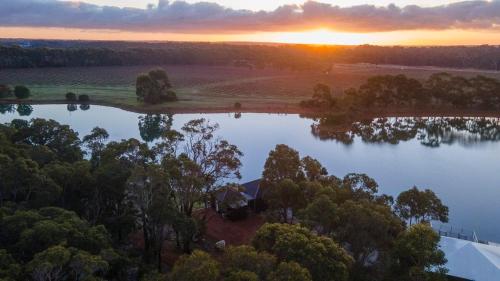 an aerial view of a lake at sunset at Caves Road Vineyard Retreat in Wilyabrup