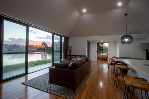 a living room with a couch and a large window at Caves Road Vineyard Retreat in Wilyabrup