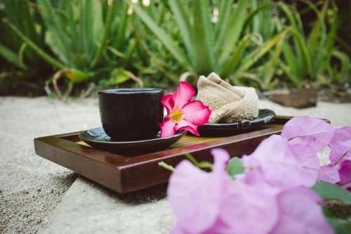 a tray with two cups and some flowers on it at Novotel Lombok Resort & Villas in Kuta Lombok