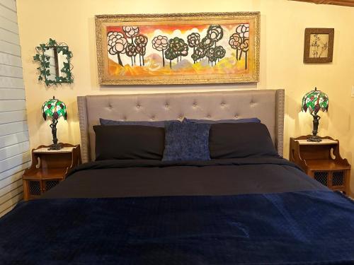 a bedroom with a bed with a blue comforter and two lamps at The Rosemary in Los Angeles