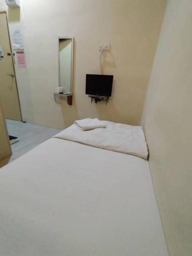a white room with a bed and a mirror at Hotel Bestari in Melaka