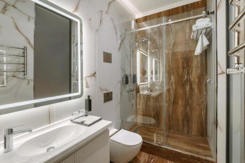 a bathroom with a shower and a toilet and a sink at Azimut Hotel Tashkent in Tashkent