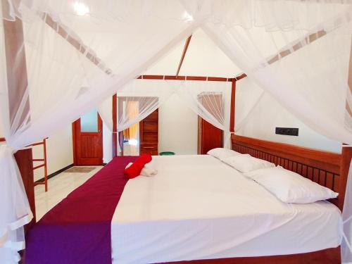 a bedroom with a white bed with a canopy at Luxury Peak Villa in Mirissa
