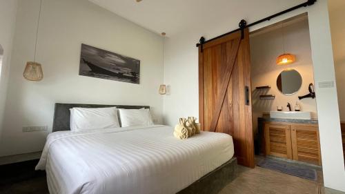 a bedroom with a white bed and a sink at Jenna in Koh Phangan