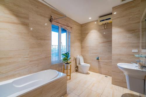 a bathroom with a tub and a toilet and a sink at WECOZY HANOI - Railway Side, The Old Quarter in Hanoi