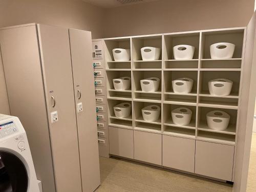 a laundry room with white cups on shelves at Glansit Akihabara in Tokyo