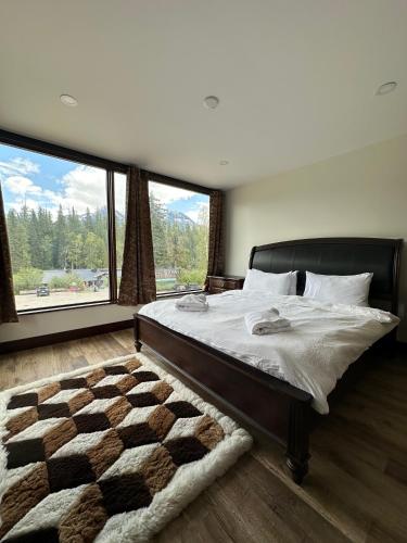 a bedroom with a large bed and a large window at River Safari Mountain View Suite in Blue River