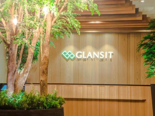 a clanish sign on a wall with trees at Glansit Akihabara in Tokyo