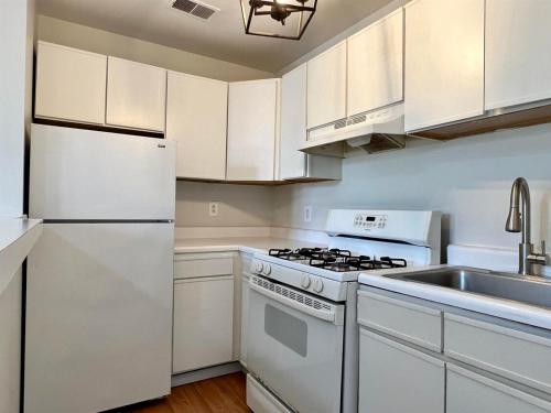 ジャージー・シティーにあるComfy apt with skyline front view Mins away from NYCのコンロとシンクのある白いキッチン