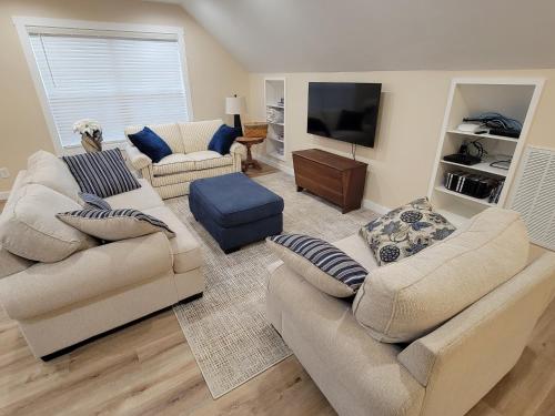 a living room with two couches and a flat screen tv at The Coach House in Heiskell