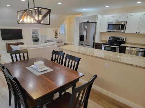 a kitchen and living room with a wooden table and chairs at The Coach House in Heiskell
