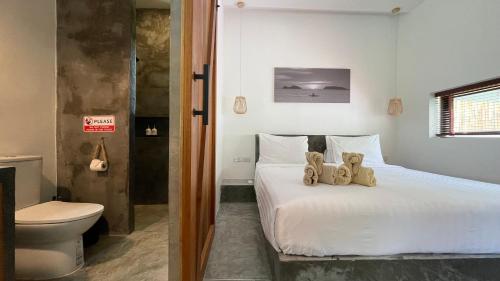 a bedroom with a bed with two teddy bears on it at Jenna in Koh Phangan