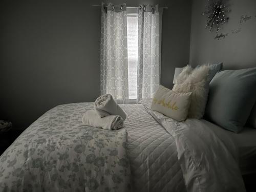 a bed with towels on it with a window at Cozy, 1st floor apartment 2bdrms Plus Semi Private room with Futon Pets with fee Family Friendly Close to Everything in Cleveland