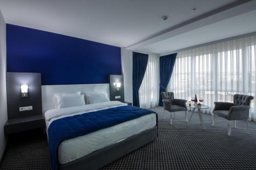 a hotel room with a bed and a blue wall at Cavit Duvan Prestige Hotel in Edirne