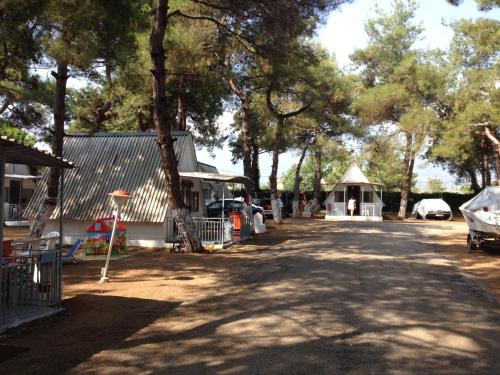a dirt road next to a building and trees at Olympos Beach in Plaka Litochorou