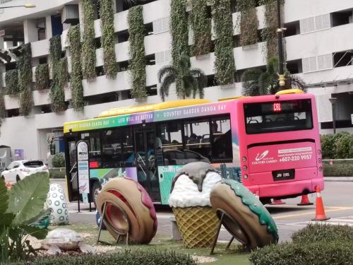 a pink bus driving down a street with an ice cream cone at Astonishing Ocean View 3 Bedroom Apartment in Johor Bahru