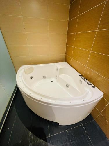 a bath tub in a bathroom with brown tiles at The Grandeur in Melaka