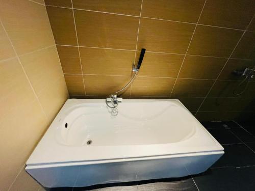a bath tub in a bathroom with a phone on the wall at The Grandeur in Melaka