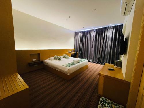 a hotel room with a bed and a window at The Grandeur in Melaka