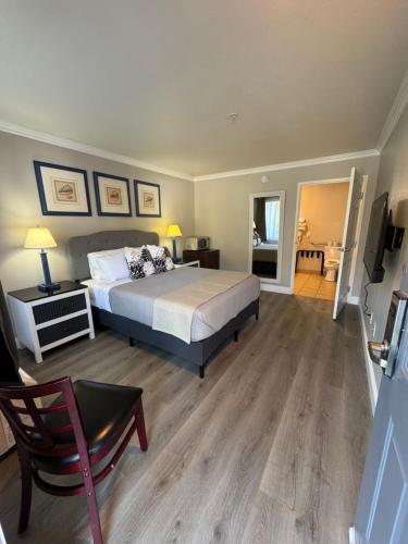 a bedroom with a bed and a table and a chair at Dune Surfer Inn in Oceano