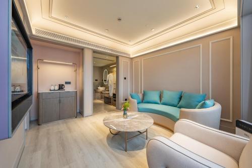 a living room with a blue couch and a table at Meilun Hotel Shanghai International Tourist Resort in Shanghai