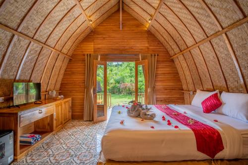 a bedroom with a large bed in a room at Taman Bidadari Eco Wellness in Pemuteran