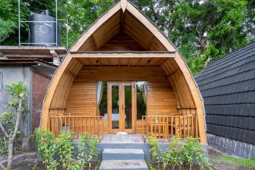 a small wooden house with a large door at Taman Bidadari Eco Wellness in Pemuteran