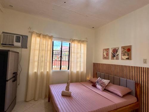 a bedroom with a large bed with a window at AisG Homestay Tres -Fully Furnished Shared Homestay FREE NETFLIX-3mins to Airport in Puerto Princesa City